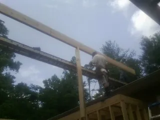 Carpenter setting a ridge beam over a new addition frame — Ice Dam Removal by Roofing Brothers in Sloughhouse