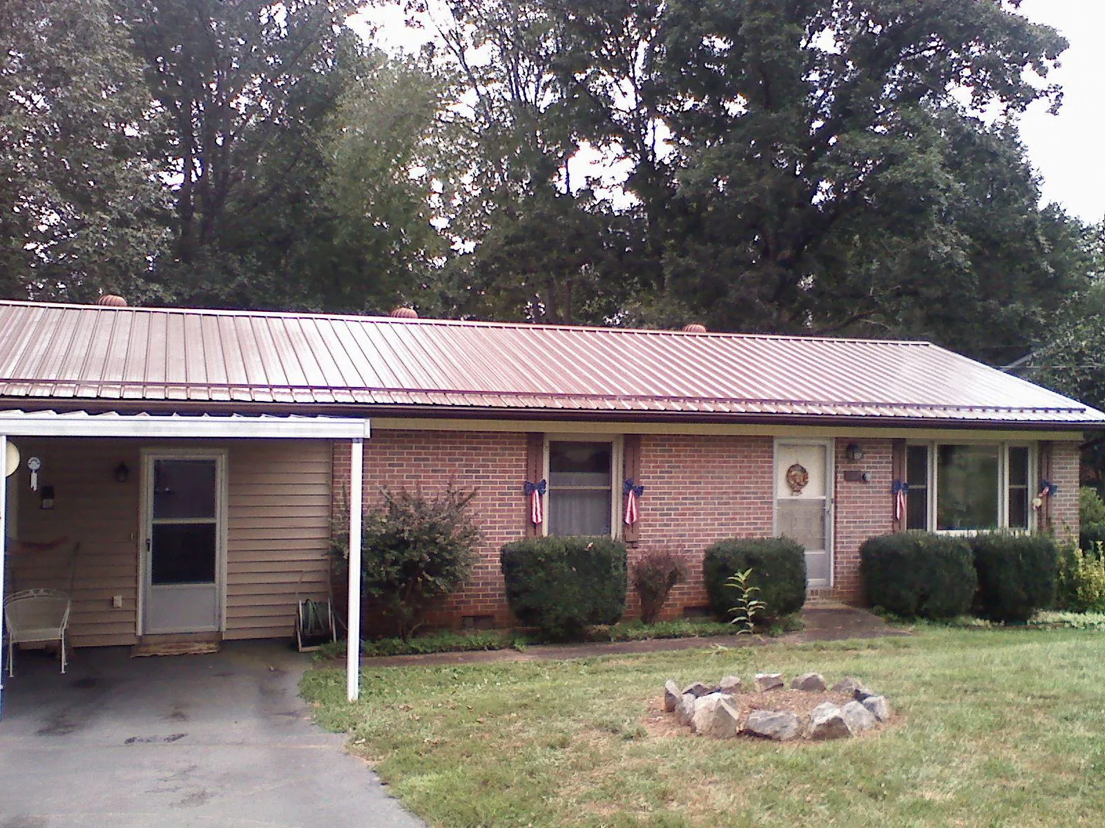 Bronze metal roof and carport on a brick ranch home — Roof Repair work by our crew in Sloughhouse
